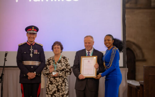 Team of people with award and kings award certificate